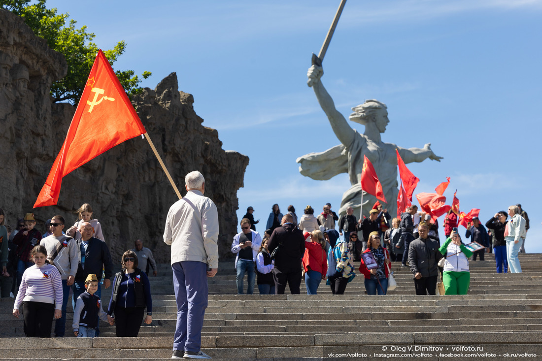 Красные гвоздики и красные знамёна на Мамаевом кургане в День Победы фотография